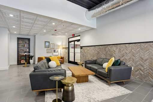 A living room with a grey couch and a wooden coffee table.