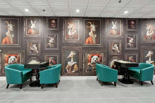 A room with a table surrounded by chairs and pictures of animals on the wall.