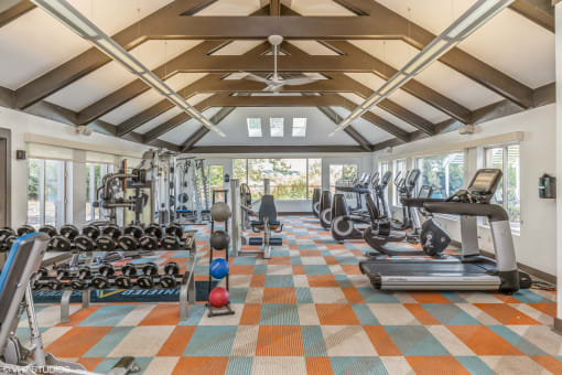 a gym with weights and cardio equipment in a building with windows at Runaway Bay Apartments, Columbus, OH