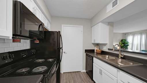 A black stove top oven with a black microwave above it. at The Local Apartments, Tennessee