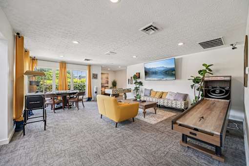A living room with a yellow chair and a wooden table.