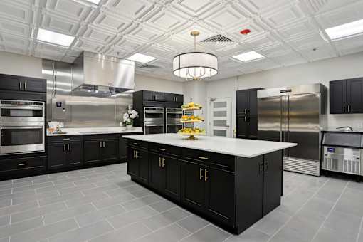 A modern kitchen with black cabinets and stainless steel appliances.
