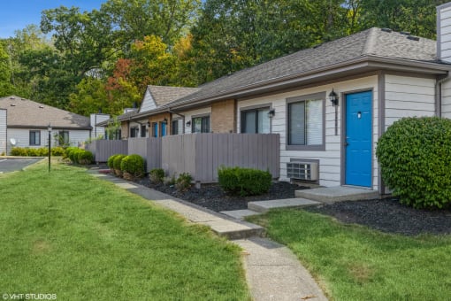 a sidewalk in front of a house with a blue door at Silvertree at Little Turtle Apartments, Westerville, Ohio