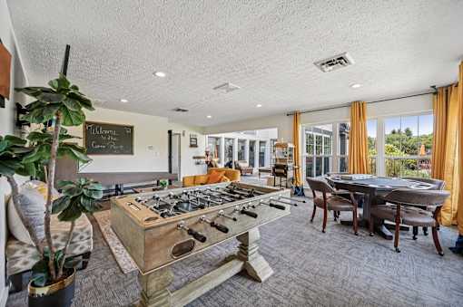 A room with a pool table and a chalkboard on the wall.