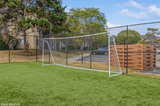 a soccer goal in a chain link fence on a grass field at Runaway Bay Apartments, Columbus, OH