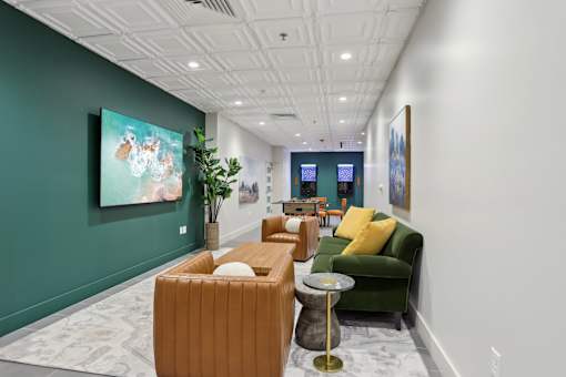 A long hallway with a green couch and a painting on the wall.