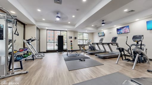 a gym with exercise equipment and yoga mats on the floor at Bristol On Union Apartment Homes, Memphis, TN, 38104