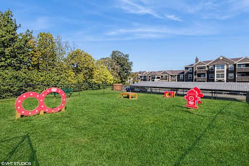 A grassy field with a red fire hydrant and a large red circle with white rings. at Island Club Apartments, Columbus, Ohio