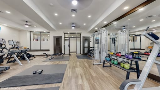 a gym with exercise equipment and mirrors on the wall at Bristol On Union Apartment Homes, Tennessee
