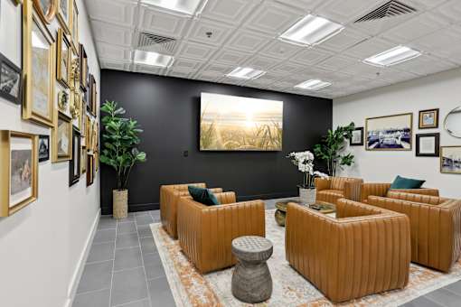 A room with orange couches and a large painting on the wall.