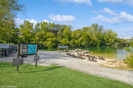 a park with a beach and a sign next to a lake at Runaway Bay Apartments, Columbus