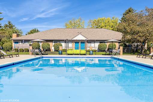 A large swimming pool in front of a house with a covered patio at Karric Place of Dublin Apartments, Ohio