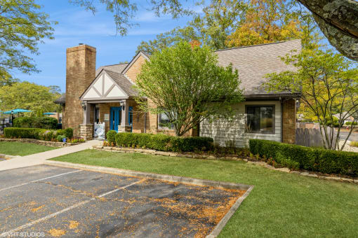 the front of a brick house with a driveway and lawn at Silvertree at Little Turtle Apartments, Ohio