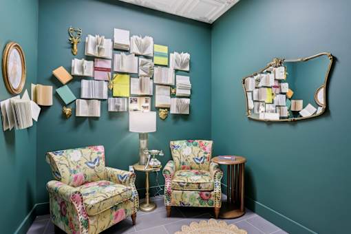 A room with two chairs and a table with a lamp on it.