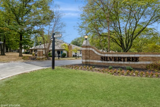 a street sign in front of a brick building with trees at Silvertree at Little Turtle Apartments, Westerville, OH, 43081