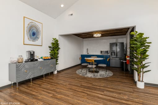 a living room with a blue and white kitchen and a table and chairs at Silvertree at Little Turtle Apartments, Westerville, Ohio