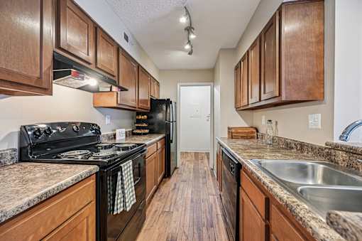 A kitchen with wooden cabinets and a black stove top oven.