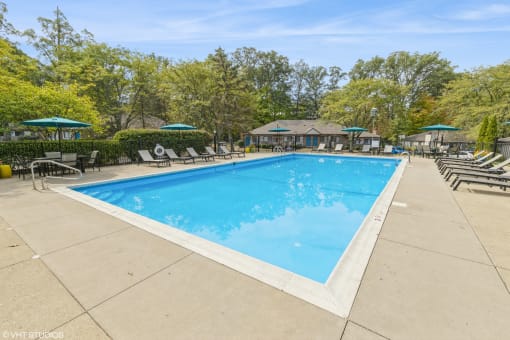 a swimming pool with chairs and umbrellas at the resort on a sunny day at Silvertree at Little Turtle Apartments, Westerville, 43081