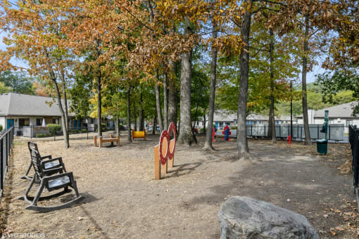 a playground in a park with benches and trees at Silvertree at Little Turtle Apartments, Ohio, 43081