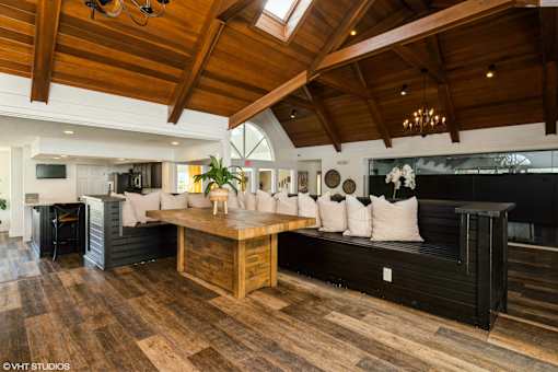 A modern living room with a wooden floor and a high ceiling at Island Club Apartments, Columbus, OH, 43235