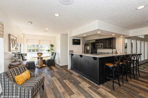 A modern living room with a bar area and a dining table at Island Club Apartments, Columbus, Ohio