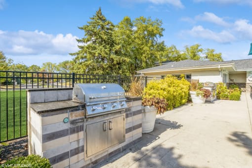 the backyard has a grill and a patio with a house at Runaway Bay Apartments, Columbus, OH, 43204
