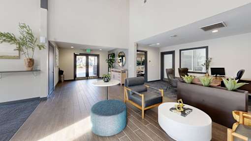 A modern waiting room with a blue ottoman and wooden chairs.