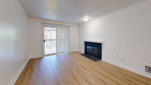 A room with a fireplace and a sliding glass door.