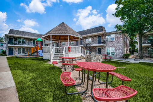 our apartments have a spacious yard with tables and chairs at Tara Oaks in Houston, TX
