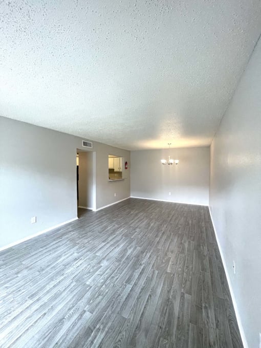an empty living room with wood flooring and white walls at Cambridge Village Apartments, Houston Texas ? 