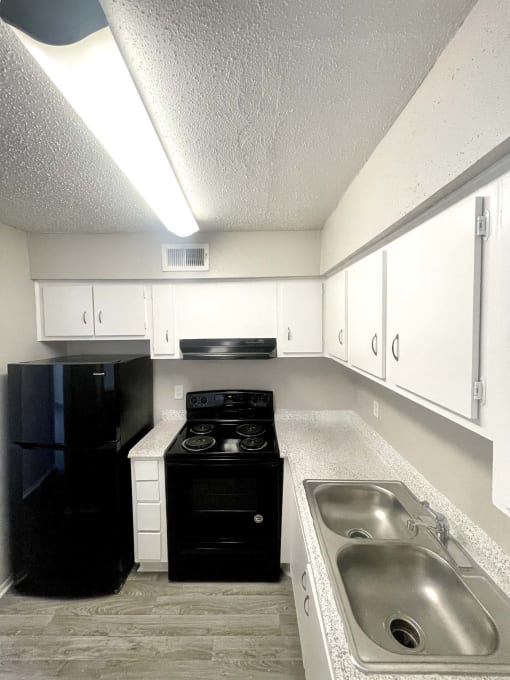 an empty kitchen with a sink and a stove at Cambridge Village Apartments, Houston ? 