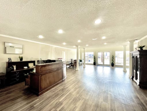 a lobby with a reception desk and a large room with hard wood floors at Cambridge Village Apartments, Texas ? 