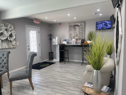 a living room with a couch and a chair and a kitchen in the background at Tara Oaks in Houston, TX