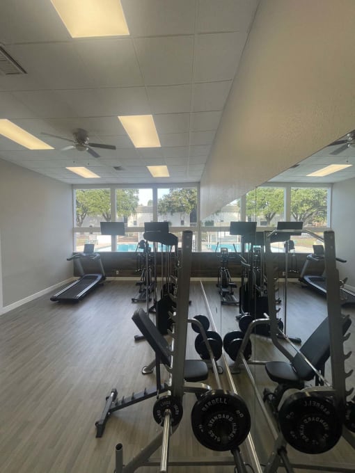 a gym with a lot of exercise equipment and windows at Whispering Oaks, Texas, 77301