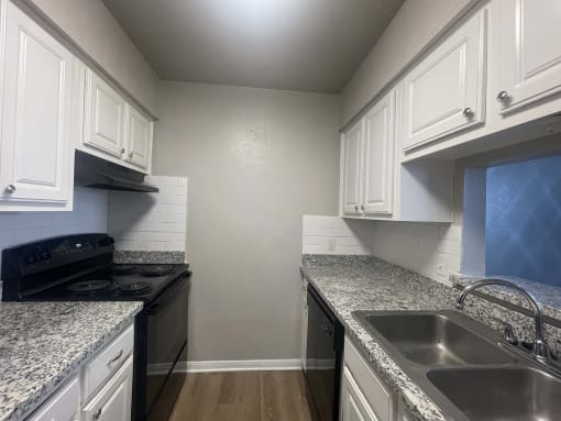 a kitchen with granite counter tops and white cabinets at Whispering Oaks, Texas ? 