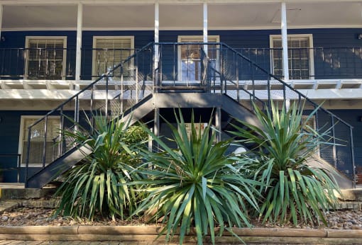 a blue building with stairs and plants in front of it at Whispering Oaks, Conroe, TX 77301 ? 
