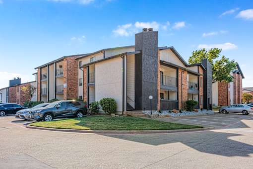 A modern building with a brick facade and a large glass window at Water Ridge Apartments , Irving, TX, 75061