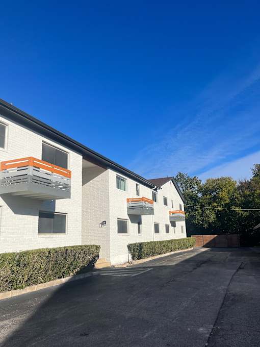 A white building with orange accents and a clear blue sky.