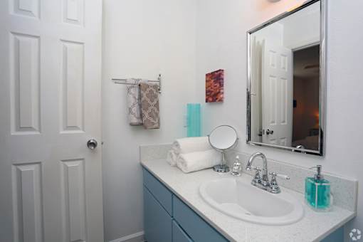 A bathroom with a white sink and a mirror.