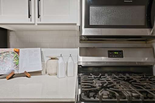 A kitchen with a stove and a microwave oven.
