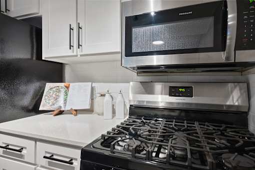 A modern kitchen with a stove, microwave, and oven.