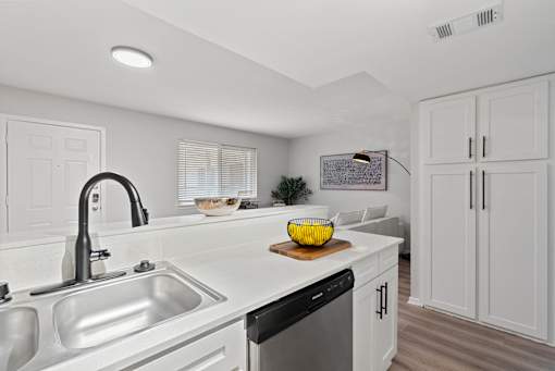 A modern kitchen with white cabinets and stainless steel appliances.