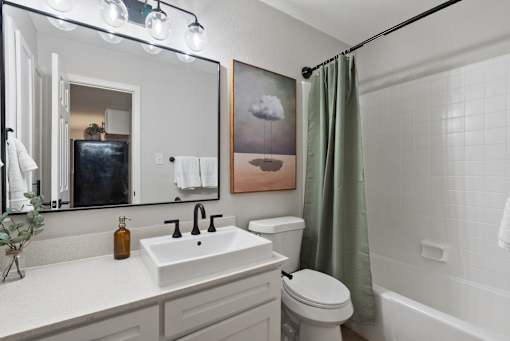 A bathroom with a white sink, toilet, and bathtub.