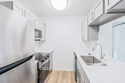 A modern kitchen with stainless steel appliances and white countertops at Water Ridge Apartments , Texas, 75061