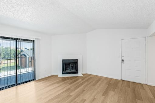 A room with a fireplace and a sliding glass door at Water Ridge Apartments , Texas