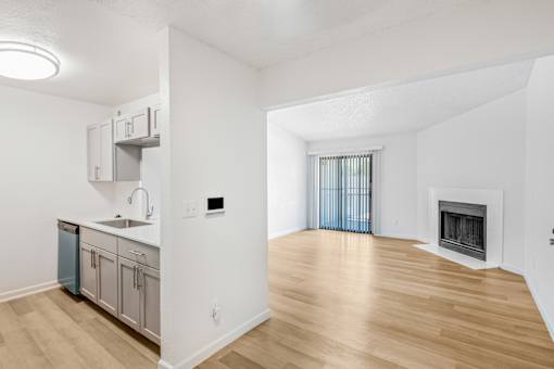 A kitchen with a sink, a refrigerator, and a fireplace at Water Ridge Apartments , Irving, TX