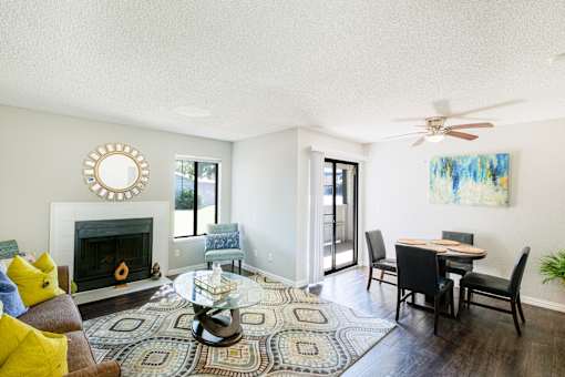 A living room with a fireplace, a dining table, and a rug at Water Ridge Apartments , Irving, TX