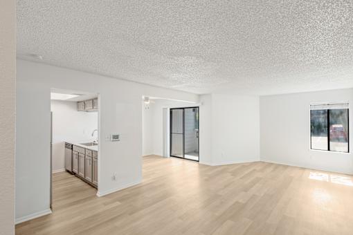 A sparsely furnished room with a kitchen area in the background at Water Ridge Apartments , Irving, TX, 75061