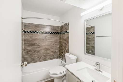 A white toilet sits next to a white sink in a bathroom at Water Ridge Apartments , Irving, TX, 75061