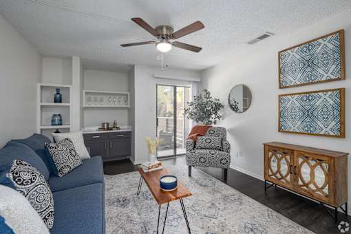 A living room with a blue couch and a wooden coffee table.